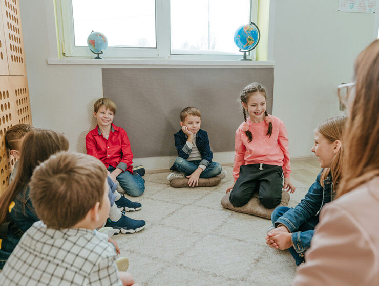 Los niños se sientan en círculo y participan en terapia de grupo bajo la supervisión de un terapeuta.